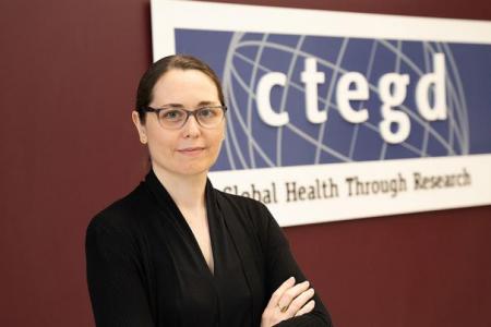 An image of Belen Cassera standing with her arms folded and looking at the camera.